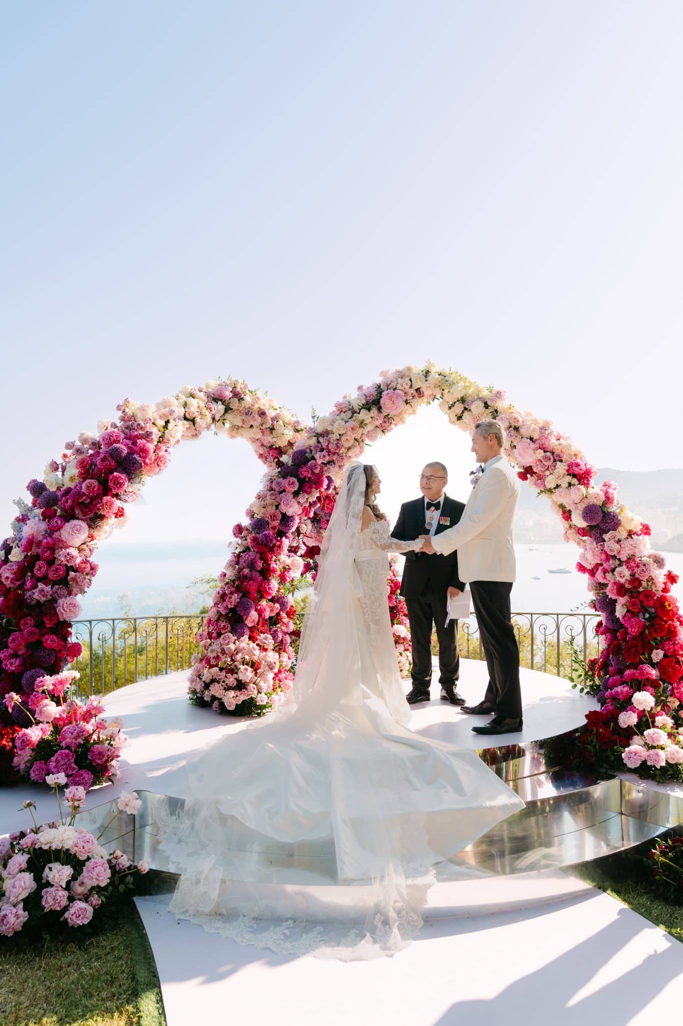 Luxury wedding of I and G at Villa K in Roquebrune-Cap-Martin, French Riviera, with a rose ceremony arch over the Mediterranean, candlelit poolside dinner and elegant table styling by The Wedding Planners Monaco.